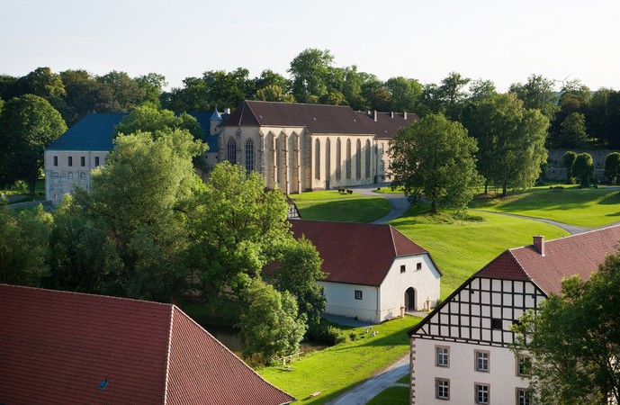 Blick auf die Dalheimer Klosteranlage mit Kirche, Scheunen und Wiesen.